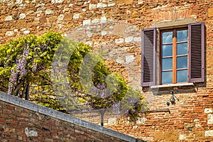 Facade with window of an old house in Pienza