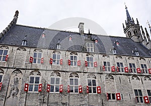 Facade with windows and red shutters of the old City Hall at Market Square in Gouda, Netherlands.