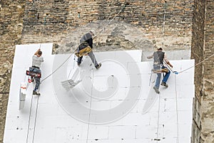 Facade workers mounting polystyrene insulation