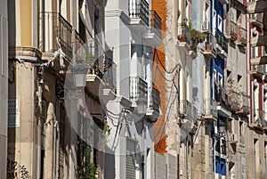 Facades of multi colored houses in a row on street of Alicante, spain