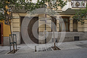 Facades of residential buildings with a brown gate and wrought iron bars on the windows