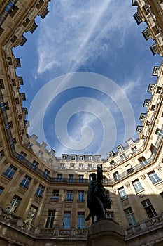 The facades of traditional French houses with typical balconies and windows on Edouard VII square . Paris.