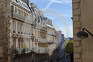 The facades of traditional French houses with typical balconies and windows. Paris.