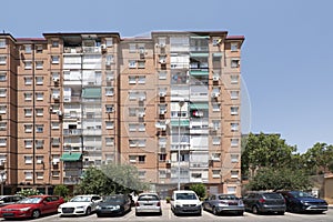 Facades of urban houses with many twin windows and balconies with green awnings