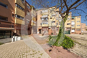 Facades of urban residential buildings with trees, portals and terraces