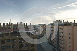 Facades of urban residential houses with many chimneys and the AtlÃÂ©tico de Madrid stadium in the background photo