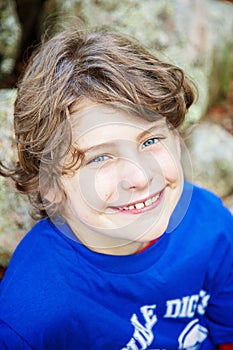 face of a 10 year old boy sitting in front of a stone wall