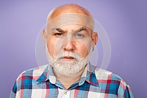Face of 60s elderly retired mature aged pensioner. Serious old mature senior man with grey beard on studio background.