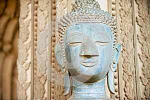 Face of an ancient Buddha statue located outside of the Hor Phra Keo temple in Vientiane, Laos.