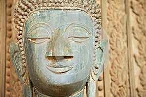 Face of an ancient Buddha statue outside of the Hor Phra Keo temple in Vientiane, Laos.