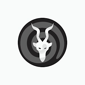 Face angora goat with long horn isolated on black circle - goat, sheep, lamb logo emblem or button icon silhouette - mammal