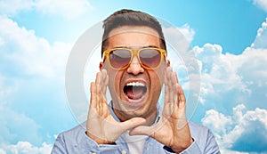 Face of angry shouting man in shirt and sunglasses