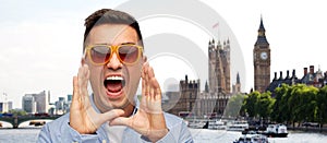 Face of angry shouting man in shirt and sunglasses