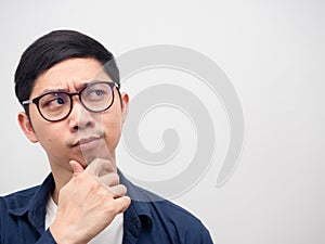 Face of asian man wearing glasses thinking and looking at copy space white background