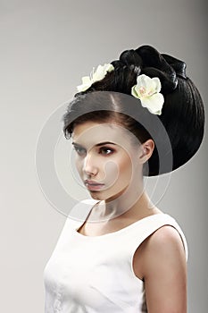 Face of Beautiful Brunette Bride Fashion Model. Elegant Hairdo with Vernal Flowers