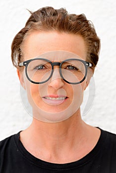 Face of beautiful mature woman wearing big eyeglasses and standing against white background outdoors