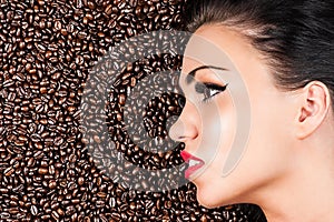 Face of a beautiful woman in coffee beans