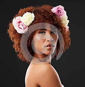 Face, beauty and flowers with a model black woman in studio on a dark background for natural skincare. Wellness, luxury