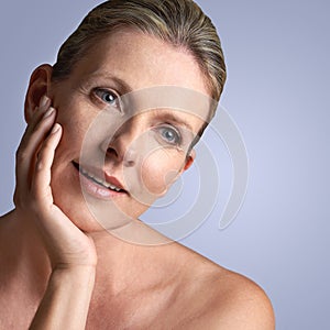 Face, beauty and mature woman with skincare or cosmetic facial isolated in a blue studio background. Cosmetics, self
