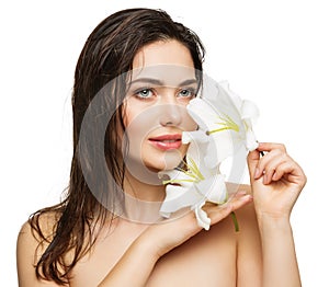 Face Beauty Model with Wet Hair. Facial Skin Care and Health. Young Woman with Full Lips and Natural Makeup holding Lily Flower