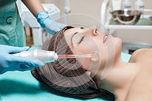 Face Beauty Treatment. Beautician makes Facial Darsonval Therapy for woman