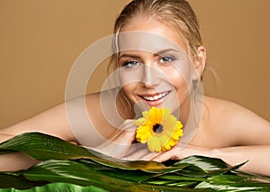 Face and Body Beauty Spa. Smiling Model with Smooth Skin and Wet Hair. Women Facial Care Cosmetics. Woman relax with Flower