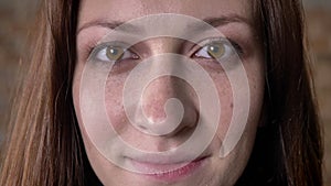 Face of brown hair girl opens eyes, watching at camera, dream concept, blurred background