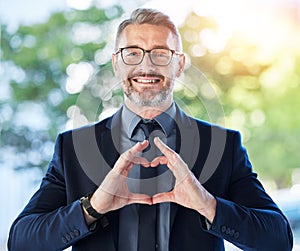 Face, business man and ceo with heart hands outdoor for trust, care and happy. Portrait, mature with love sign, smile