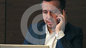 Face business man working on notebook and calling by mobile hone in office