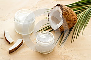 Face care. Coconut cream in glass jar on beige background