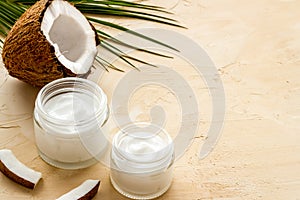 Face care. Coconut cream in glass jar on beige background copy space