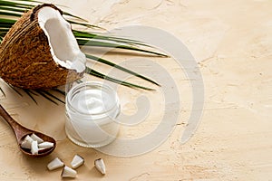 Face care. Coconut cream in glass jar on beige background copy space