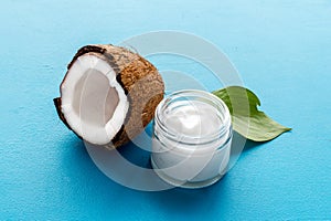Face care. Coconut cream in glass jar on blue background