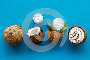 Face care. Coconut cream in glass jar on blue background top-down