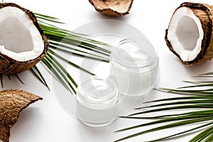 Face care. Coconut cream in glass jar on white background