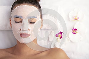 Woman with cotton face mask in beauty salon