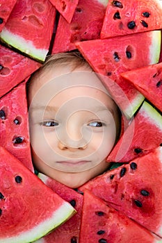 A boy framed by triangular pieces of watermelon.Cute portrait of a baby