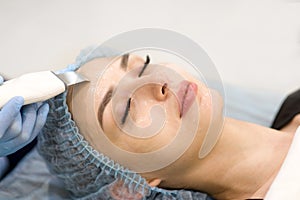 Face cleaning in a beauty salon - close-up of a woman`s face.