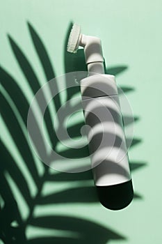 Face cleanser, facewash dispenser with the shadow of a palm leaf