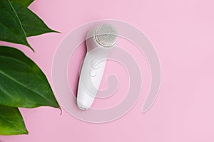 Face cleansing brush on pink background photo