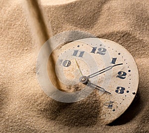 Face of clock in sand