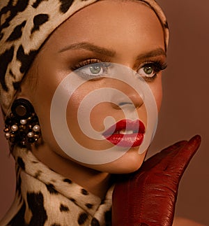 Face close-up. Hat and scarf in a leopard pattern.