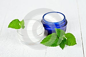 Face cream in jars with urtica leaves photo