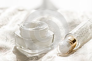 Face cream moisturizer in a jar and serum gel bottle, luxury skincare product