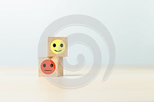 Face emotion positive and negative concept. wooden cube with smiley face and sad face icon. satisfaction and service ranking