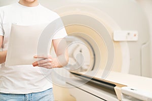 without a face. engineer fills in maintenance documents. computer tomograph.