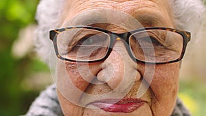 Face, expression and wrinkles of senior woman with glasses looking sad, old and frail during retirement in Indonesia