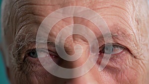 Face and eyes of mature man. Close-up of blue eyes with wrinkles on face of senior male. Portrait of elderly person.