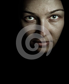 Face and eyes of spooky mystery woman in the dark