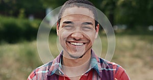 Face, funny and happy man in park laughing at comedy, joke or humor outdoor in nature. Portrait, laughter and African